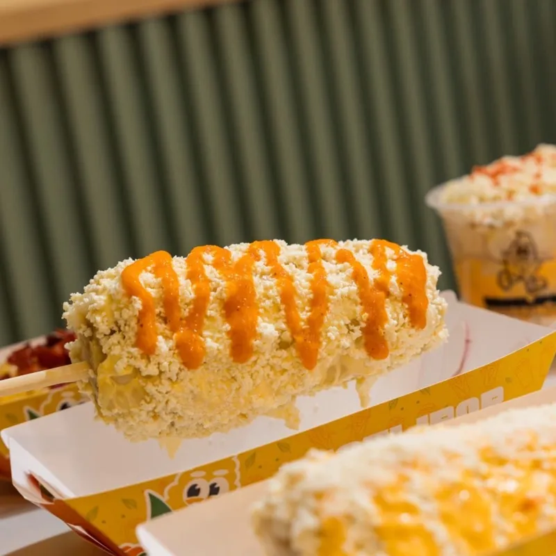 Choclo entero con crema y queso en bandeja Choclipop
